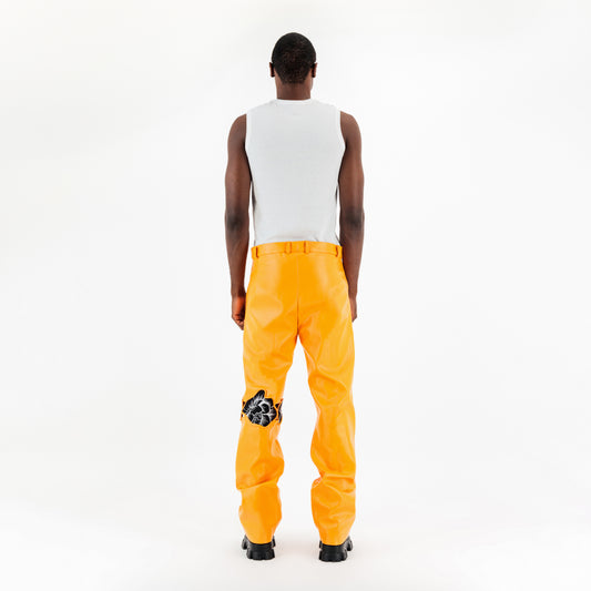 Pantalon orange en similicuir avec détails fleuris