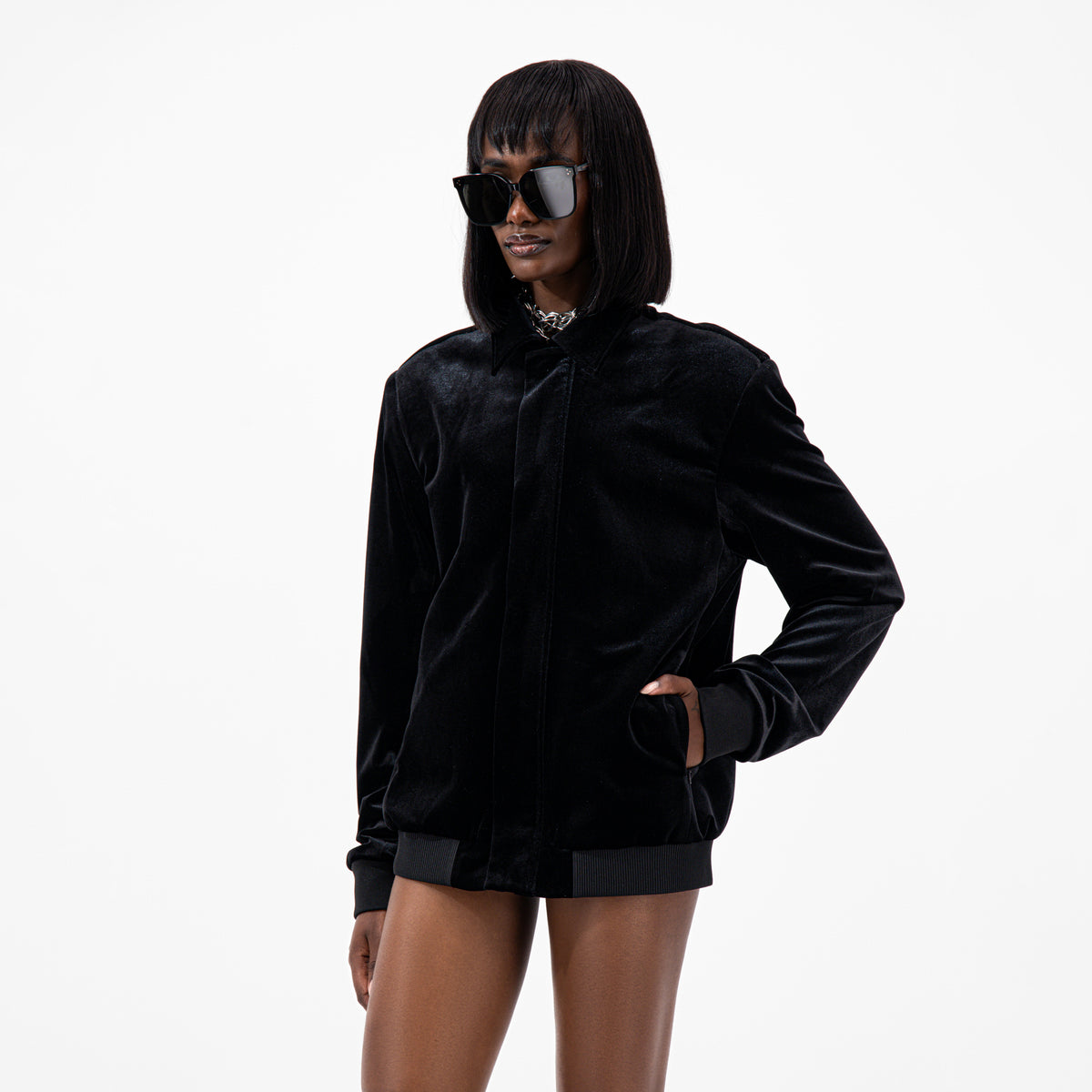 Black Velvet Bomber Jacket worn by model, featuring a sleek design with sunglasses for a stylish look.