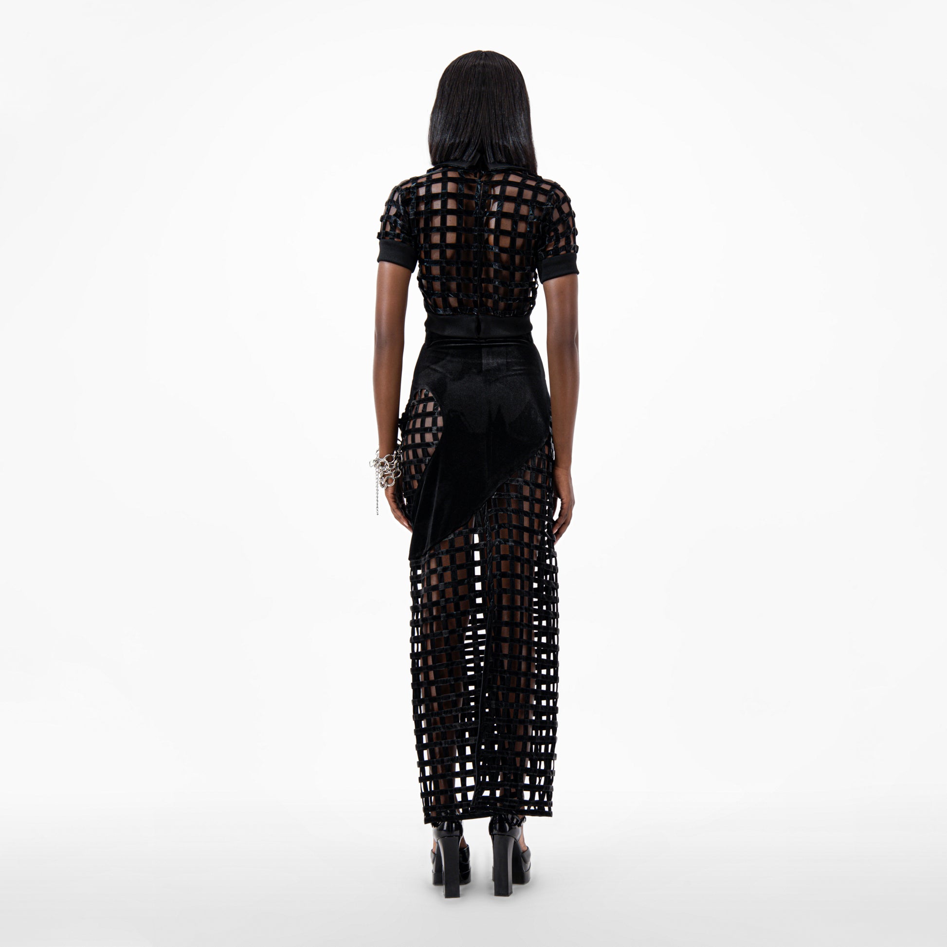 Black Velvet Maxi Skirt showcasing a stylish back view with intricate cutouts and a sleek silhouette.