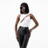 Model wearing a cowrie shell embellished tank top with front cut-out and multicolored string detailing.