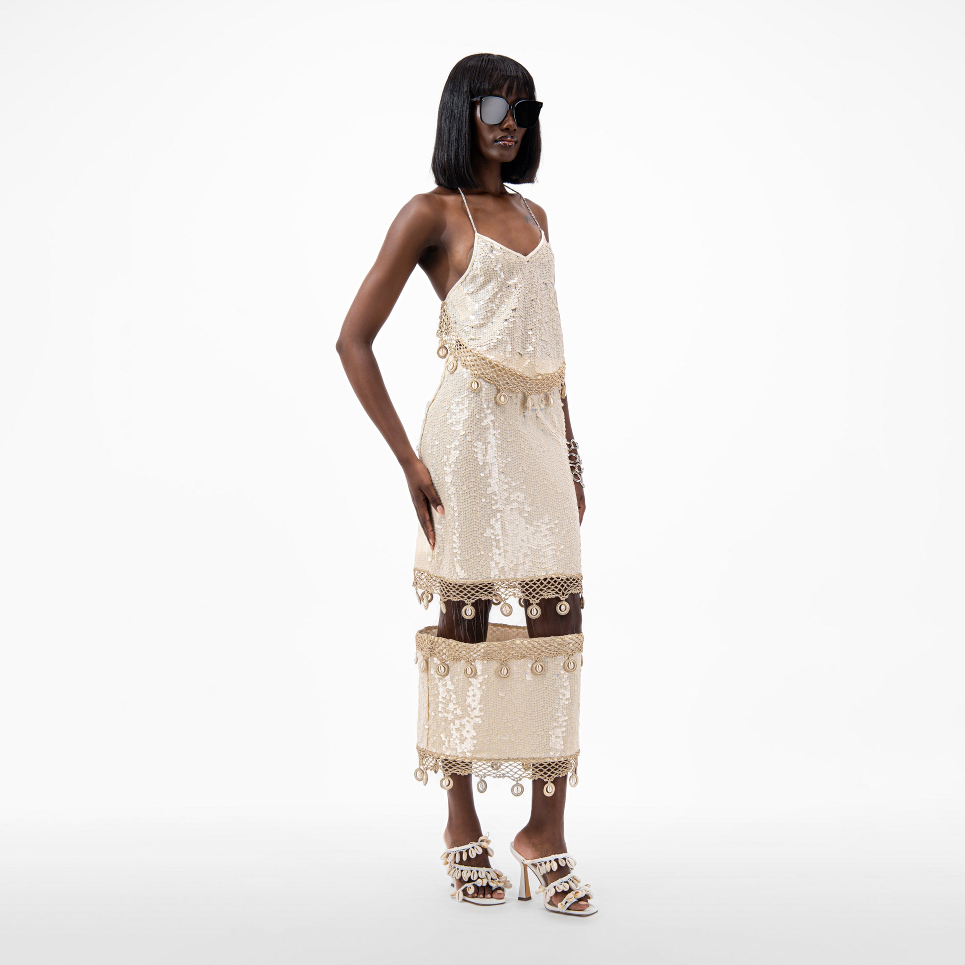 Model wearing a Floating Sequin Midi Skirt featuring crocheted hemming and cowrie shells details.